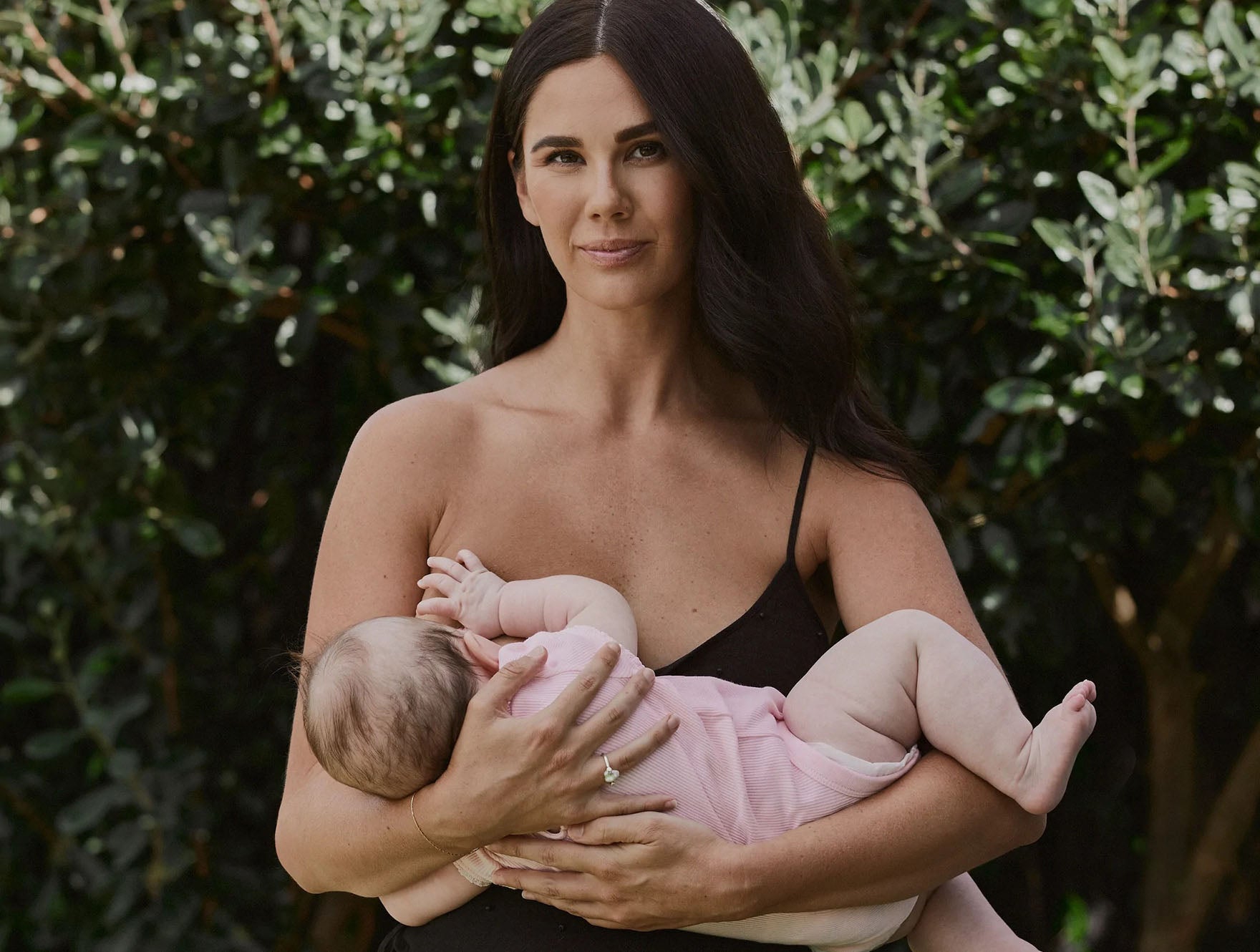 Mother holding her baby breastfeeding using Two Islands Milk Maker